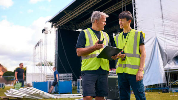 Event crew setting up barriers at stage
